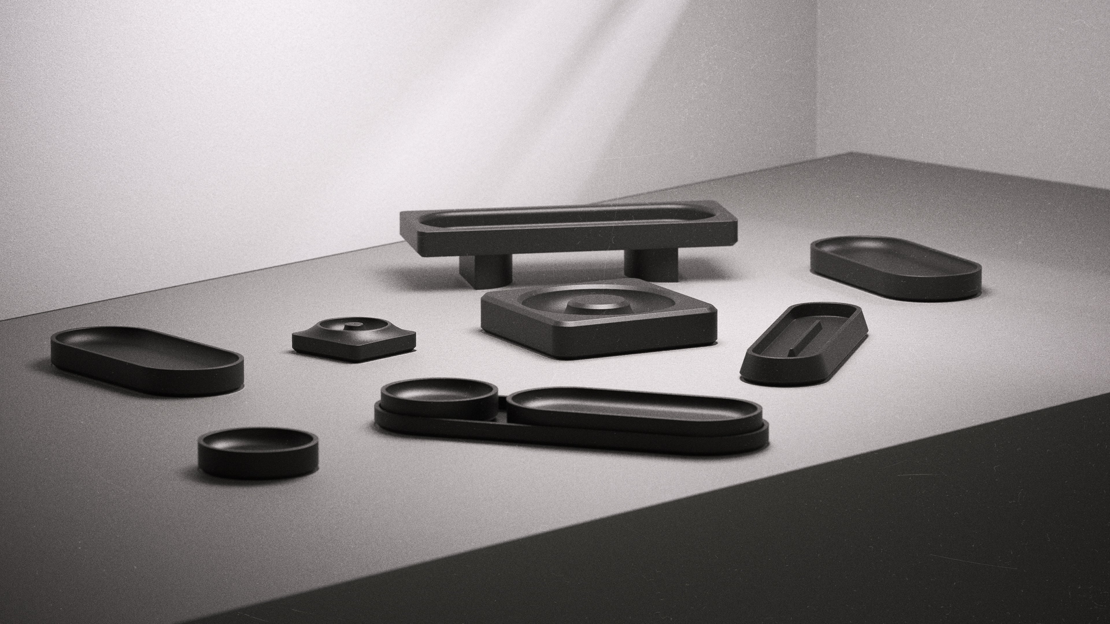 Set of black jesmonite trays & holder on a gray surface with a white background