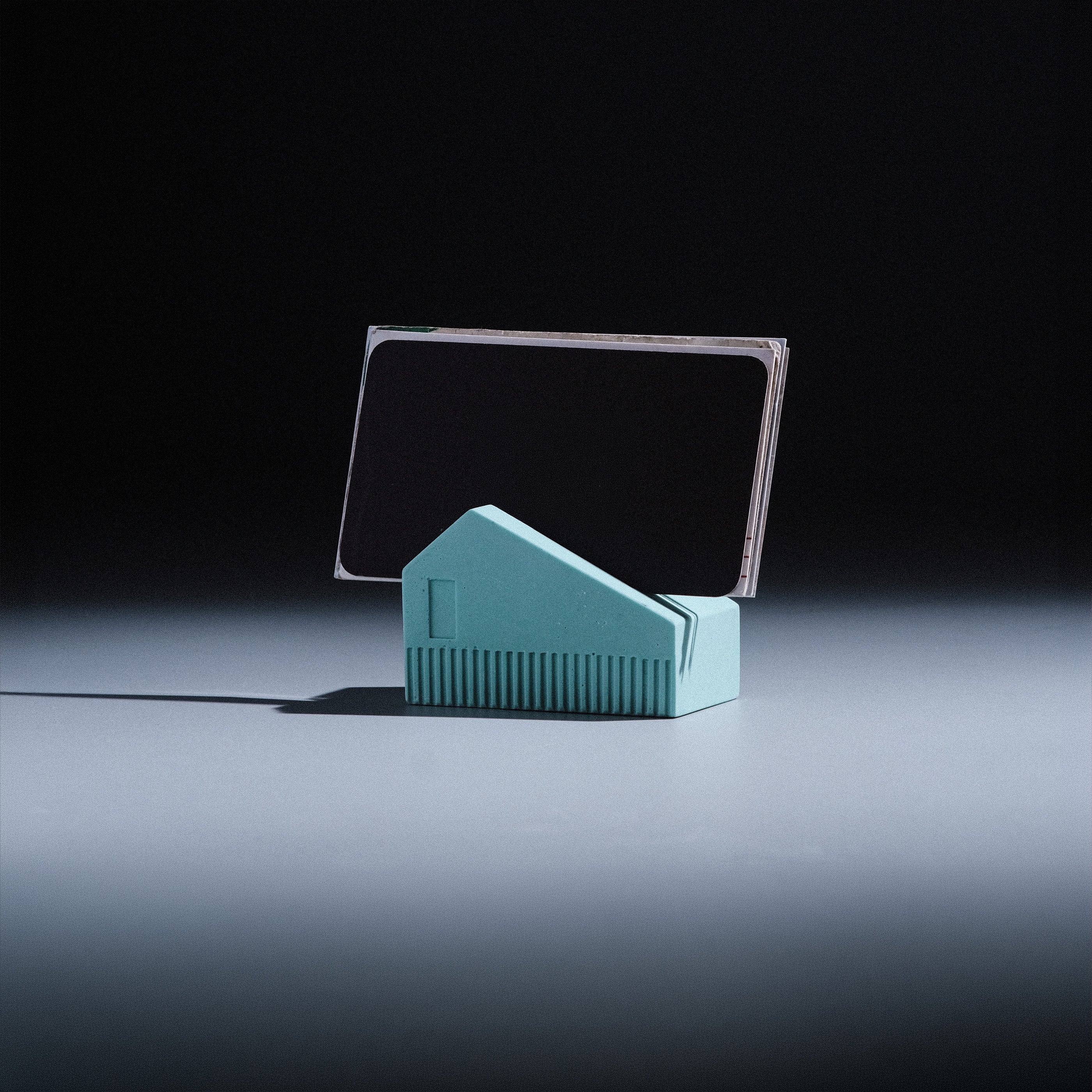 Koya Card Stand by Kuro Design holding business cards at a natural angle, minimal Jesmonite desk accessory made in India